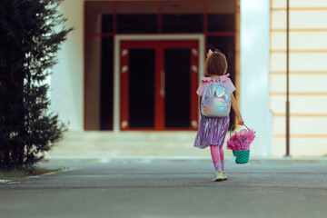  Girl Goes to School with a Basket of Flowers and Schoolbag. Grateful student ready for school to...
