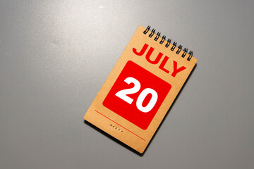 Wooden calendar July 20 on a white background close up
