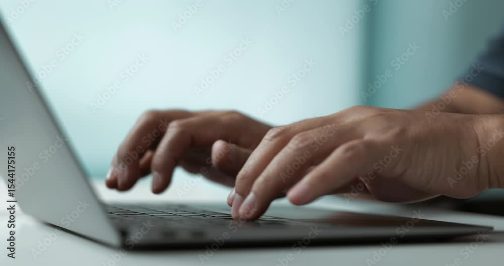 Poster typing on laptop keyboard at modern workspace