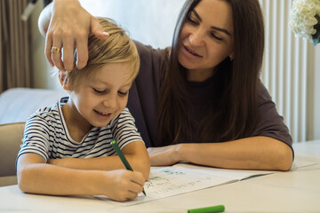 Happy mother and son drawing together.