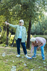 Lifestyle and people concept. Two elderly sisters blowing soap bubbles in a summer park.