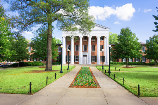 Lyceum Building at Ole Miss at the end of parallel sidewalks with early spring flowers