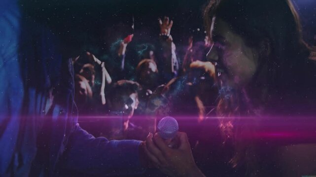 Host extending mic, singer grabbing mic singing music as crowd dancing under growing nebula visuals