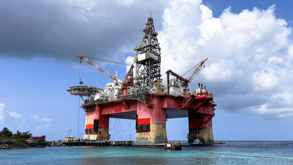 Photo of floating "La Muralla"  a large piece of offshore drilling equipment right next to the beach in Caribbean sea in Curaçao. A semi-submersible drilling rig that is undergoing reactivation.