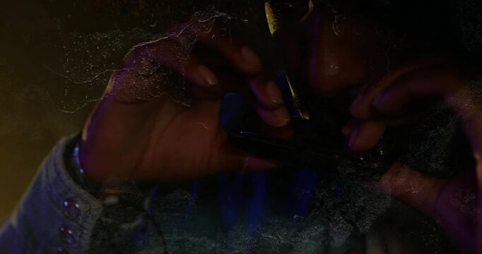 Male musician raising harmonica to lips, playing for creating melody under amber blue lighting
