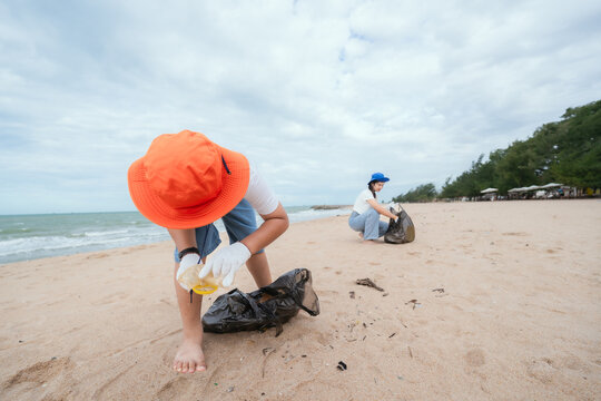 Community members participate in beach cleanup activity to preserve marine environment on sunny day