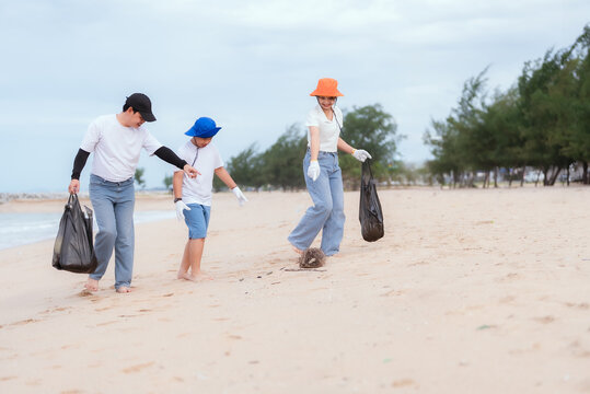 Family participates in beach cleanup activity while promoting environmental awareness on a cloudy day - Powered by Adobe