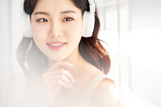 Female Listening to Music with Headphones in Bright Room