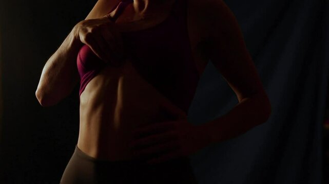 female athlete demonstrates abs, athletic physique, fitness at home
