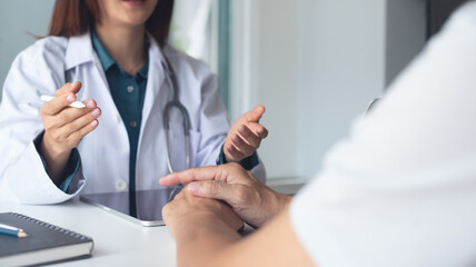 Female doctor and patient in appointment at doctor office with advice. Medical clinic, male patient...