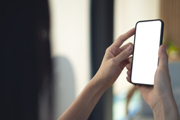 Mockup blank white screen mobile phone. Woman hand holding, using smartphone at coffee shop, template for mobile app design, social media marketing, close up