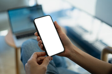 Mockup blank white screen mobile phone. Woman hand holding, using smartphone at coffee shop, template for mobile app design, social media marketing, close up