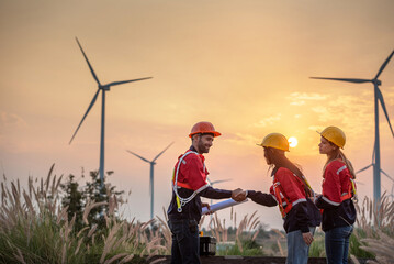 engineer technician team raise joy hand for success happiness at wind power plant machine . silhouette Group of colleague technician professional worker discussion maintenance electronic wind turbine © BESTIMAGE
