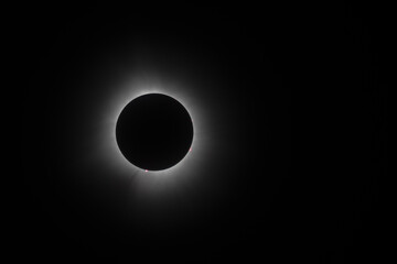 Solar eclipse during totality with corona and solar flares visible