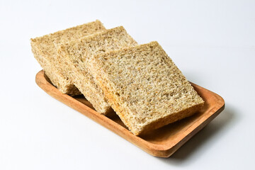 Close up view of whole wheat sliced bread on long wooden plate. isolated on white background. clipping path.