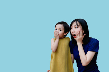 Excitement shared between a woman and a child during a playful moment in a bright, minimalist...