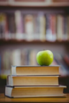 Green apple on stack of books