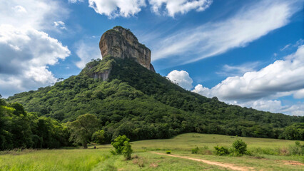 Obraz premium Imposing mountain rising above verdant foliage, suggesting outdoor adventure and exploration