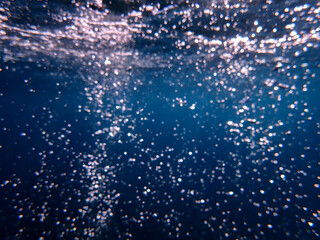 Fototapeta premium Ocean blue underwater with sunrays, Underwater Sea Deep Water Abstract Sunshine, sea wave , clean waters in summer time, Natural underwater seascape, sand on ocean floor and water surface with sunligh