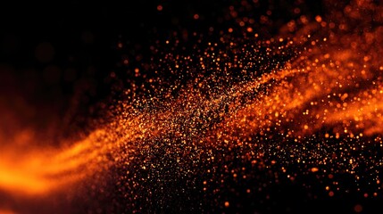 Orange particles suspended in motion against a dark background.