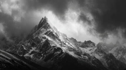 Obraz premium Majestic Mountain Peak Emerging From Clouds: A Breathtaking Landscape.