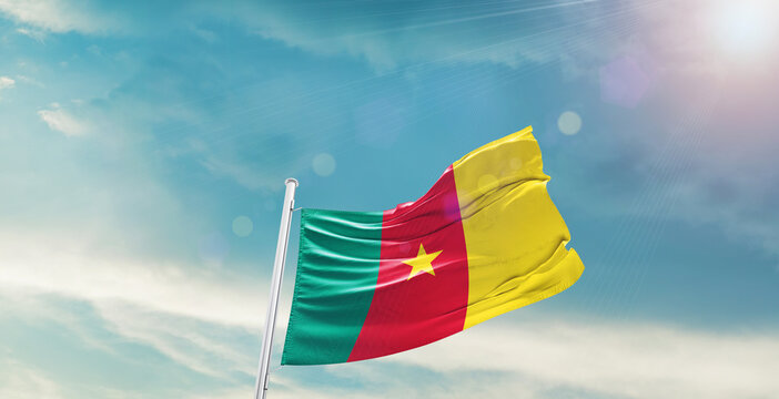 Cameroon national flag waving with beautiful sky. 