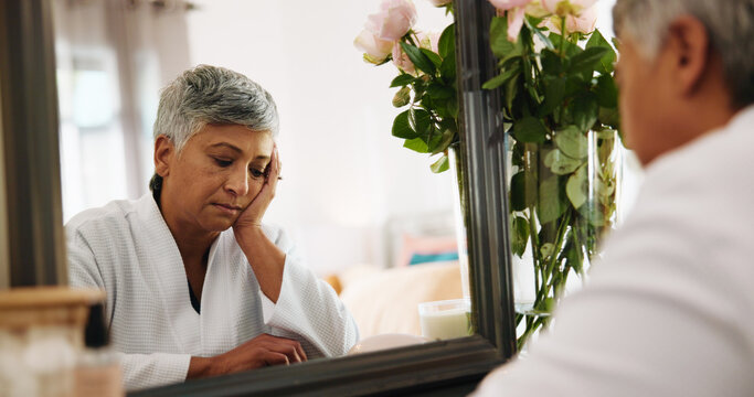 Sad, senior woman and thinking in bedroom for grief, mourning loss and insecure of skincare. Contemplating, elderly person and self doubt with reflection, regret decision and shame for appearance