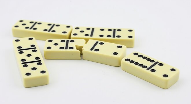 Scattered dominoes playfully rest on bright white background. AI Generated