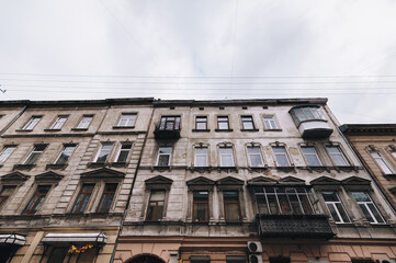 Many old windows with shutters on the facade of a house in Lviv, Ukraine.