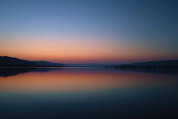 Fototapeta premium A serene landscape featuring a calm lake reflecting the vibrant colors of the twilight sky at dusk time