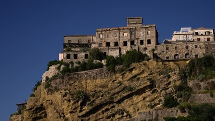 Old town of Pizzo Calabro rising on a tufa cliff under blue sky in Calabria, Italy