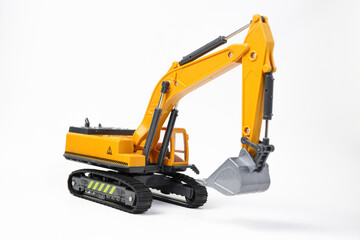 A miniature model of a yellow excavator on isolated on white background. Highlighting construction equipment. Yellow excavator model toy

