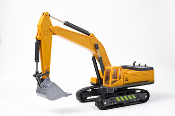 A miniature model of a yellow excavator on isolated on white background. Highlighting construction equipment. Yellow excavator model toy
