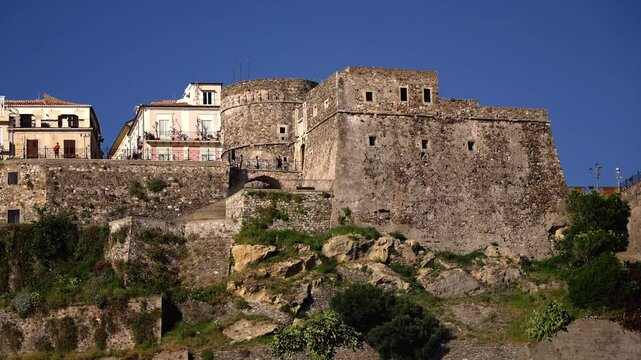 Stone walls of Murat Castle rising above residential buildings in Pizzo Calabro, Calabria, Southern Italy, on a sunny day