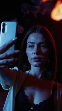 Woman Taking Selfie by Bonfire at Night