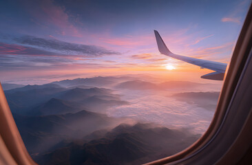 Airplane wing view from plane window over foggy mountains at sunset. Sky and sun above clouds. Scenic flight travel picture. Mountain top below clouds, airline business journey.