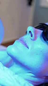 Woman Receiving Blue LED Light Therapy Facial Treatment in Spa