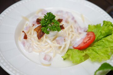Close up homemade spaghetti carbonara with ham cheese and parsley on white dish. Traditional Italian food