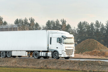 White lorry driving along countryside highway