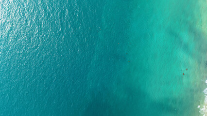 Aerial view of tranquil turquoise water meeting white sand beach, creating a serene and inviting tropical paradise, perfect for relaxation and escape