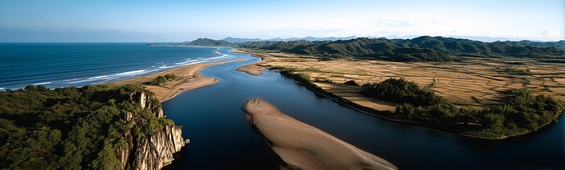 Coastal Panorama: A breathtaking wide-angle view captures the seamless confluence of a tranquil river and the vast ocean, embracing the rugged shoreline and lush landscapes.