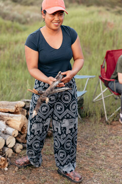 Thai woman gathering firewood for bonfire at campsite