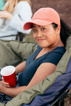 Woman relaxing in camping chair enjoying outdoor party