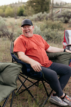 Happy camper laughing and relaxing in nature while camping
