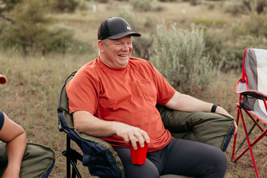 Happy camper laughing and relaxing in nature while camping