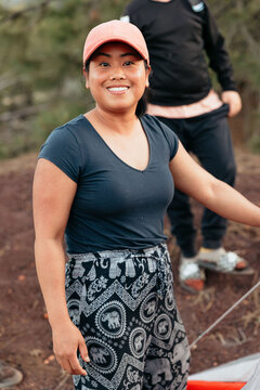 Camper smiling and setting up tent in campground