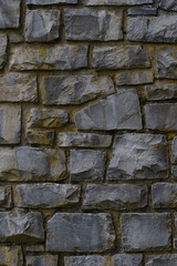 Medieval wall built with dark stone masonry