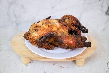 Roasted chicken whole on white plate	
