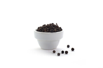 Pepper seeds in a cup placed on a white background.