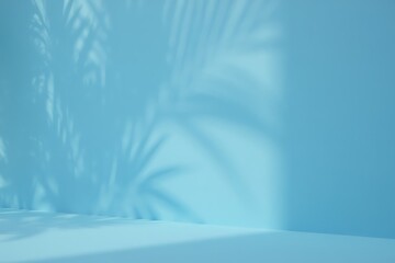 Fototapeta premium Serene Blue Background with Palm Leaf Shadows Perfect for Summer Product Displays or Tropical Designs